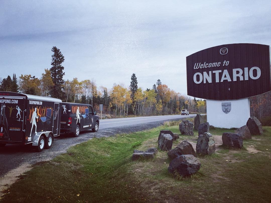 Tiger's wrapped truck and trailer beside the Welcome to Ontario sign.