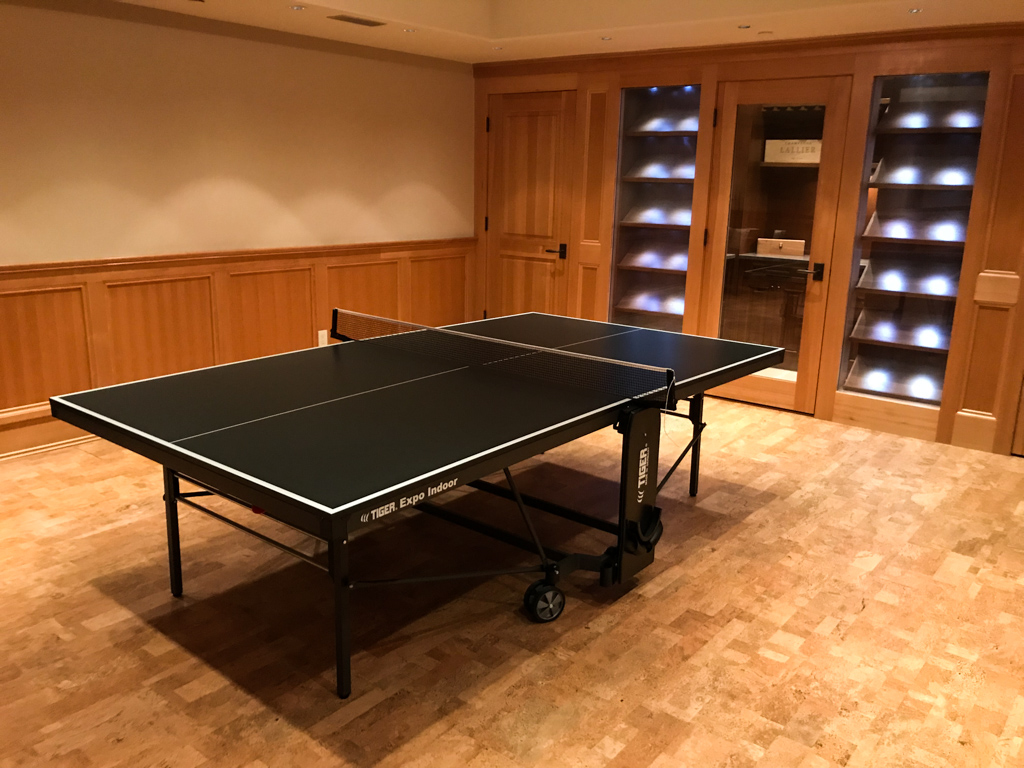 Dark coloured ping pong table in an indoor setting.